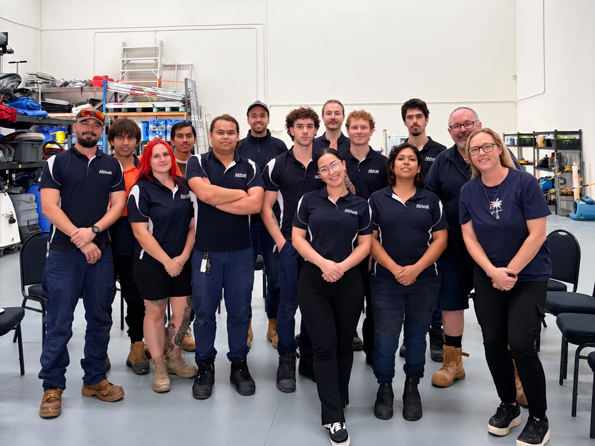 Mould Professionals Australia team in navy uniforms standing together in the workshop