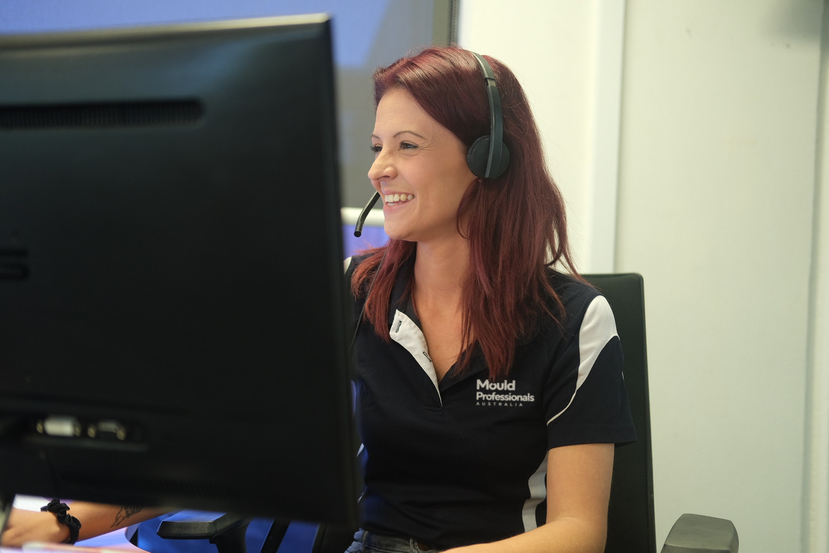 Smiling customer service team member with a headset taking a mould inspection booking